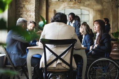 Groupe de professionnels discutant dans un espace de coworking moderne et accessible