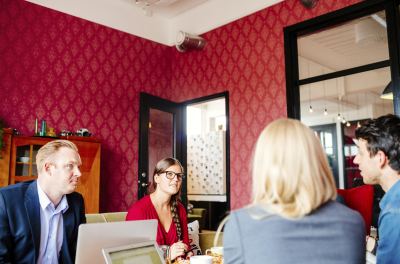 Réunion professionnelle dans un espace de coworking avec des participants autour d'une table.