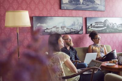 Trois personnes sur un canapé dans un espace de coworking décoré de photos en noir et blanc
