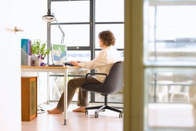 Homme travaillant dans un espace de coworking lumineux avec ordinateur et écran supplémentaire.