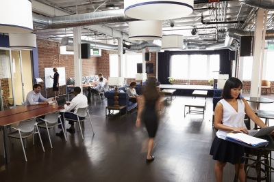 Espace de coworking avec design industriel, tables individuelles et espaces de réunion