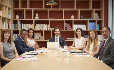 Équipe professionnelle réunie autour d'une table de conférence dans un espace de coworking moderne et bien aménagé.